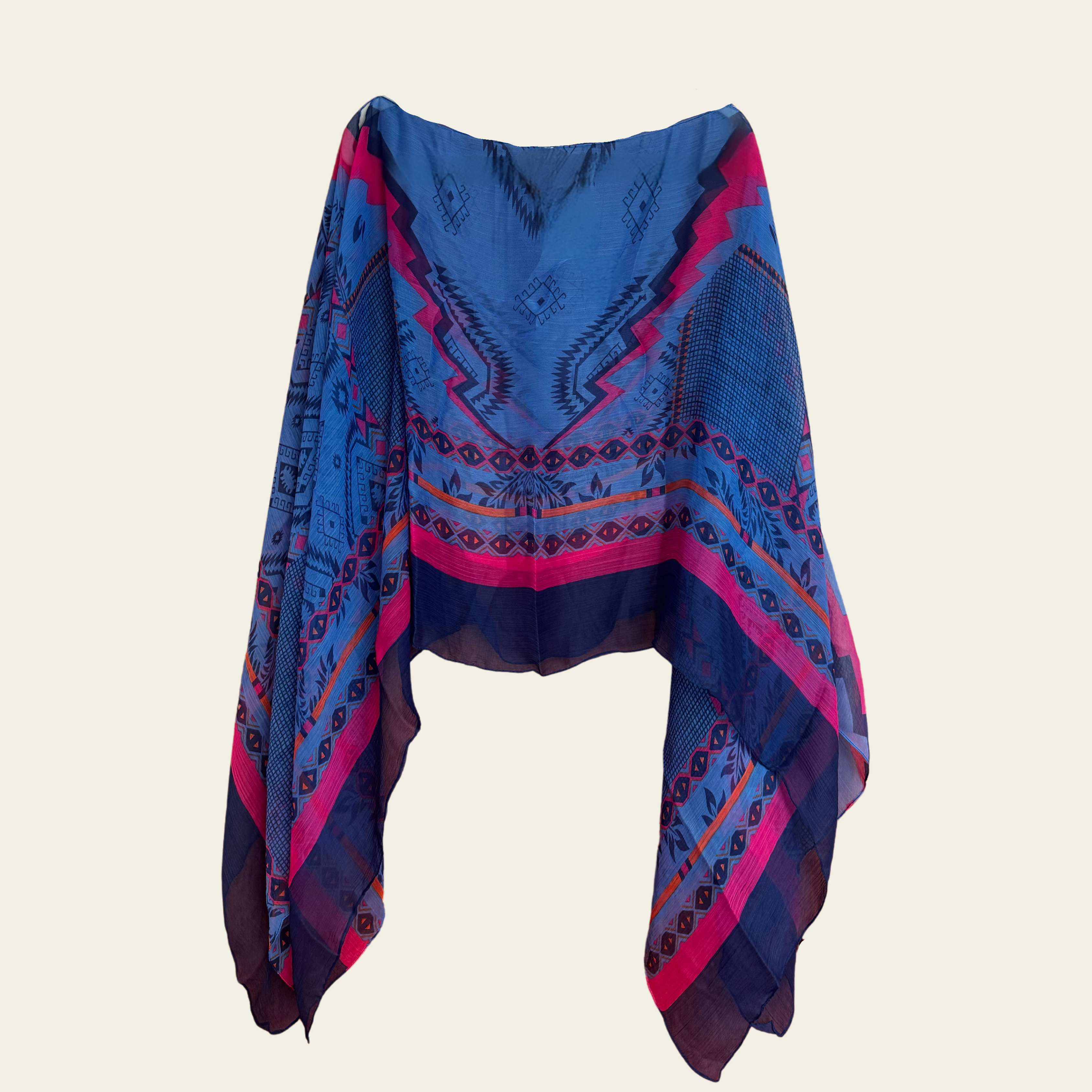 This lightweight chiffon poncho drapes beautifully, showcasing a vibrant blend of blue and pink with an abstract print.